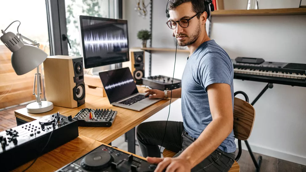 DJ trabajando en algunas pistas mientras usa gafas
