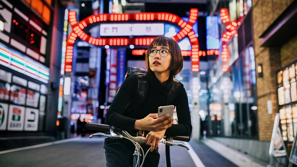 Mujer montando en bicicleta en una calle concurrida, con gafas monofocales